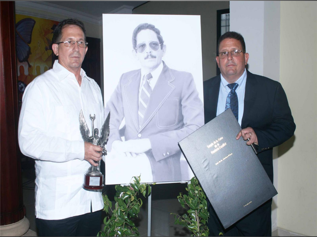 Hijos del profesor José de Jesús Sánchez posan frente a su retrato en el primer ceremonial de la fama de Espaillat.  